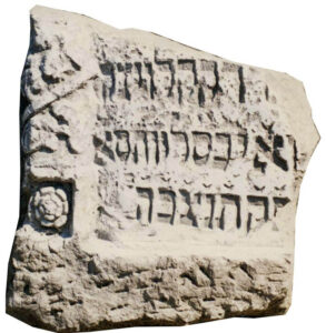 Fragment macewy wykonanej z piaskowca. W polu inskrypcyjnym wklęśle żłobiony tekst w języku hebrajskim z datą: 10 Kislew (5)461 (21 listopad 1700 r.). Napis ujęty w częściowo zachowane prostokątne obramienie wykonane w głębokim reliefie w formie wieńca laurowego, u dołu zakończonego pełnoplastyczną rozetą. 